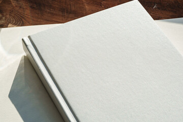 Books by the window on wooden background in sunlight