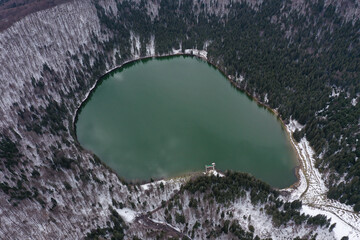 Aerial drone view of a volcanic crater lake at winter. Flying above Sfanta Ana lake, Szent Anna...