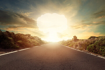 Nuclear bomb explosion. Mushroom cloud on horizon and empty decert road