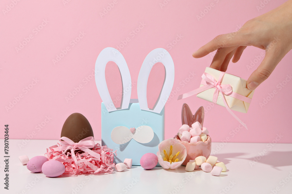 Wall mural Blue gift box with rabbit ears and chocolate eggs