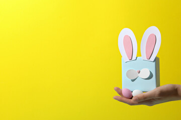 Blue gift box with rabbit ears on a yellow background