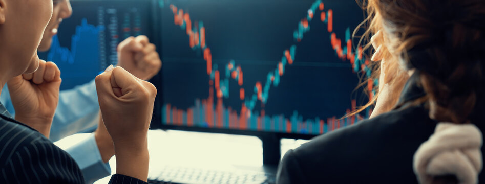 Happy Successful Business People Celebrate While Look At Increasing Stock Market Chart On Black Background Displayed On Computer. Smart Investor Cheering Their Success Investment. Burgeoning.