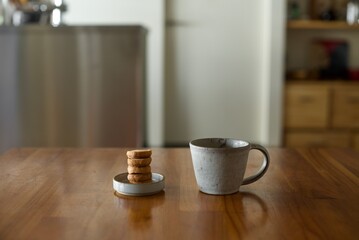 縦に積んだおやつのクッキーとマグカップの紅茶