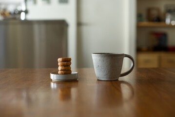 縦に積んだおやつのクッキーとマグカップの紅茶