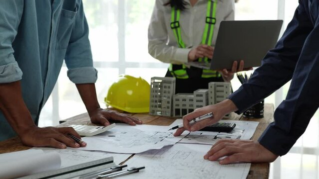 Team of engineers meeting holding worker helmets in city construction office Industrial Project Manager Foreman Engineer meeting to work as a team Professional team in Asian industry.