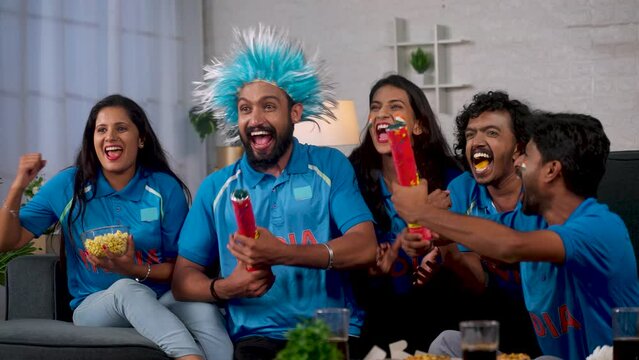 Group of Indian cricket fan celebrating victory of Team India by shouting and screaming while watching on tv at home - concept of supporters, friends gathering and championship - Powered by Adobe