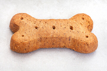 single large dog biscuit in bone shape on mottled grey