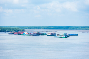Mekong delta - river panorama with barges near the river bank.
