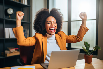 Ecstatic businesswoman celebrating success at her office desk