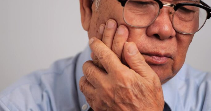 Asian elderly man suffering from toothache.
