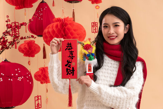 New Year's greetings, a young Asian woman holding a Spring Festival couplet