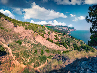 Hiker on the mountain walk path. Aerial summer view of Crimean Mountains. Sunny morning seascape of Black sea. Active tourism concept background..
