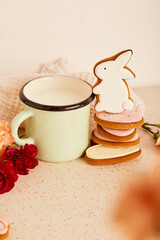 Cozy hygge milk mug with cute rabbit cookies. Springtime holiday background.