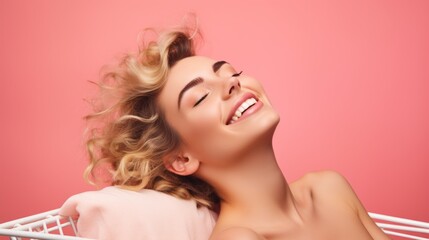 Close-up of a beautiful happy smiling young woman lying on a pillow in a shopping cart on a pink background with a copy space. Advertising Discounts, sale in stores, bargain shopping concepts. - obrazy, fototapety, plakaty