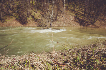 Springtime River with Rushing Waters and Lush Green Trees on the Shore