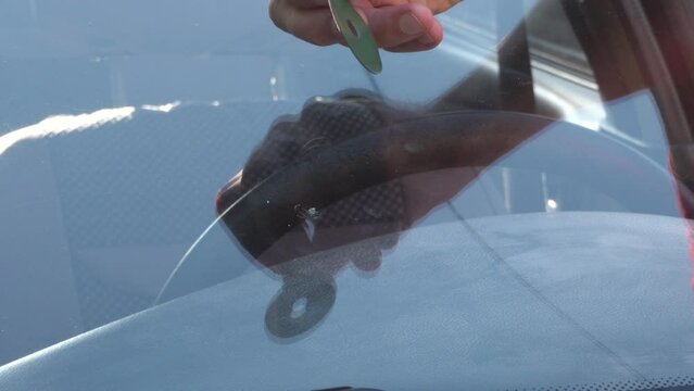car windshield repair, a man glues the windshield of a car, cracked glass in a car
