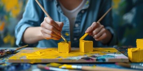 A woman is painting with yellow paint on a canvas. This image can be used for artistic or creative projects
