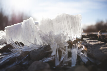 Beautiful close-up of intricate ice crystals on rocks glistening in the warm sunlight