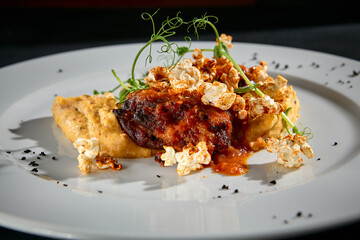 Savory beef medallions with vegetable puree on a textured black surface, a closeup of fine cuisine