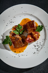 Top view of beef tongue with roasted potatoes on a white plate