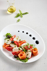 Salmon and mozzarella Caprese salad with fresh tomatoes, top view. Ideal for culinary magazines and healthy eating blogs