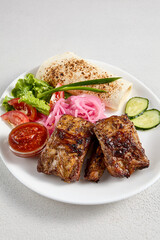 Barbecue pork ribs with fresh vegetable garnish and flatbread, perfect for grill menus and culinary blogs