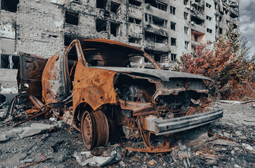 Fototapeta na wymiar burnt blown up car against the background of a destroyed house in Ukraine