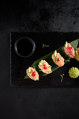 Elegant spicy sushi assortment with salmon, shrimp, tuna, and eel, top view on dark slate