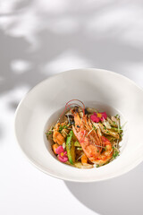 Zucchini Seafood Sauté with Shrimp and Elegant Floral Garnish on Shadowed White