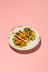 Gluten-free tacos with sweet potato mousse and turkey on a vintage plate with pink background