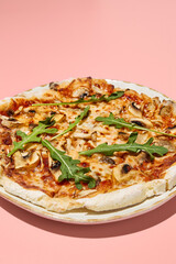 Close-up of a gluten-free pizza with mushrooms and tomatoes, presented on a stylish plate with a pink backdrop