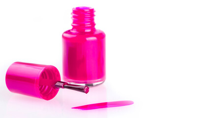 Close up of the pink nail polish bottle and drop on white background