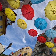 CITY LANDSCAPE - Tenement houses and colorful umbrellas against the blue sky  © Wojciech Wrzesień
