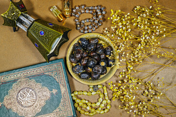 muslim book with arabic calligraphy Quran translation : holy book of Muslims and oud perfume and censer, dates fruit, tasbih and prayer mat. iftar ramadan concept
