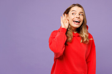 Young curious nosy fun blonde woman she wears red hoody casual clothes try to hear you overhear...