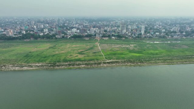 Aerial perspective of Rajshahi city in Bangladesh, nestled by the serene banks of the Padma River. Marvel at its vibrant urban landscape, rich heritage in this captivating drone footage. 4k