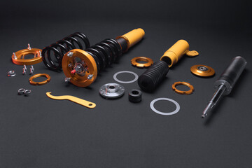 suspension tuning, coilovers, shock absorbers and front springs in yellow and gold colors for a sports drift car on a dark background	