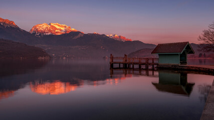 Paysage du lac d'Annecy en Haute-Savoie au coucher du soleil en hiver entouré de montagne dans les...
