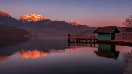 Zelfklevend Fotobehang Paysage du lac d'Annecy en Haute-Savoie au coucher du soleil en hiver entouré de montagne dans les Alpes françaises © michel