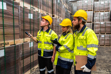 Warehouse worker men and woman in safety uniform checking stocks working together in distribution factory warehouse 