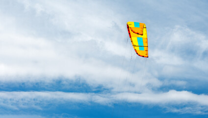 Colorful paraglider against the blue sky. Paraglider sail preparing to fly. Sky background and...