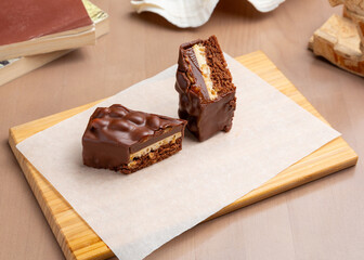 Chocolate Snickers cake on a wooden board.