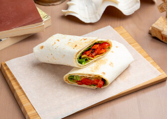 Vegan shawarma with vegetables on a wooden board.