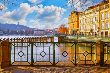 Prague, Czech Republic. Panoramic view at Vltava river with blue sky and white clouds. Warm sunny day in Praha city. Traditional architecture of old prague houses. Scenic landscape.
