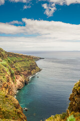 Green slopes diving into the ocean.