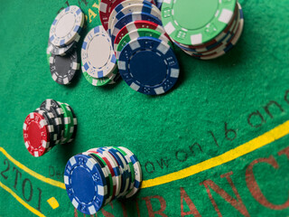 Poker chips for betting in gambling, casino green desk