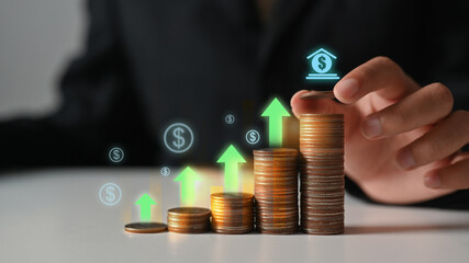 Businessman hand stacking coins with heights up arrow icons. Income Management and saving money...