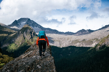 Woman hiker climbing to mountain top in tibet