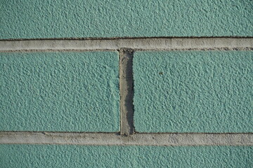 Macro of blue green brick wall with light grey mortar joints