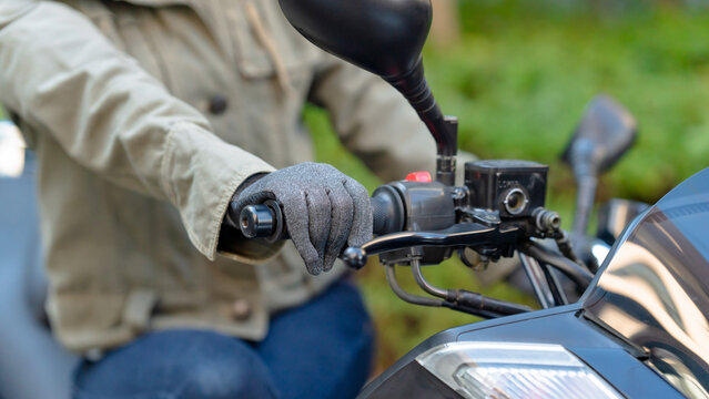 バイクに跨る女性の手元